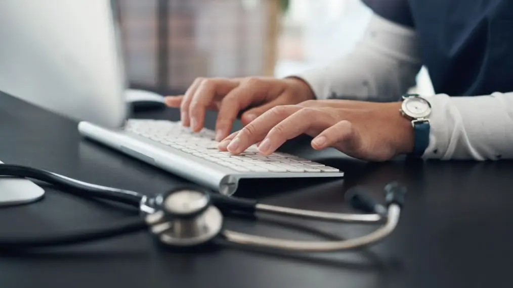 Healthcare office worker typing at computer