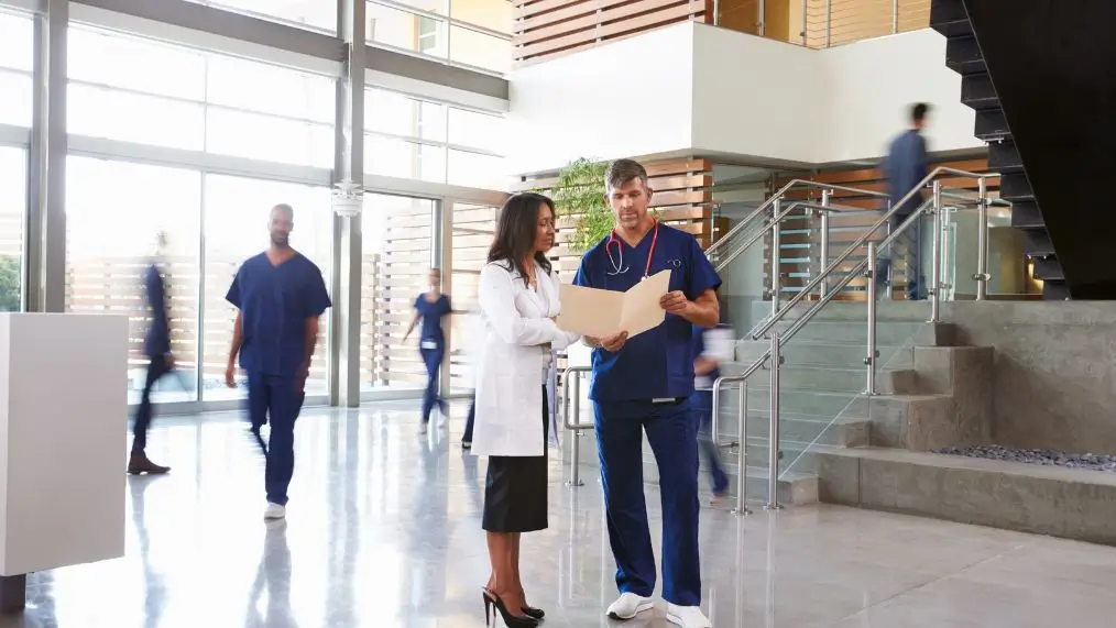 Two healthcare workers in a hospital looking at a chart