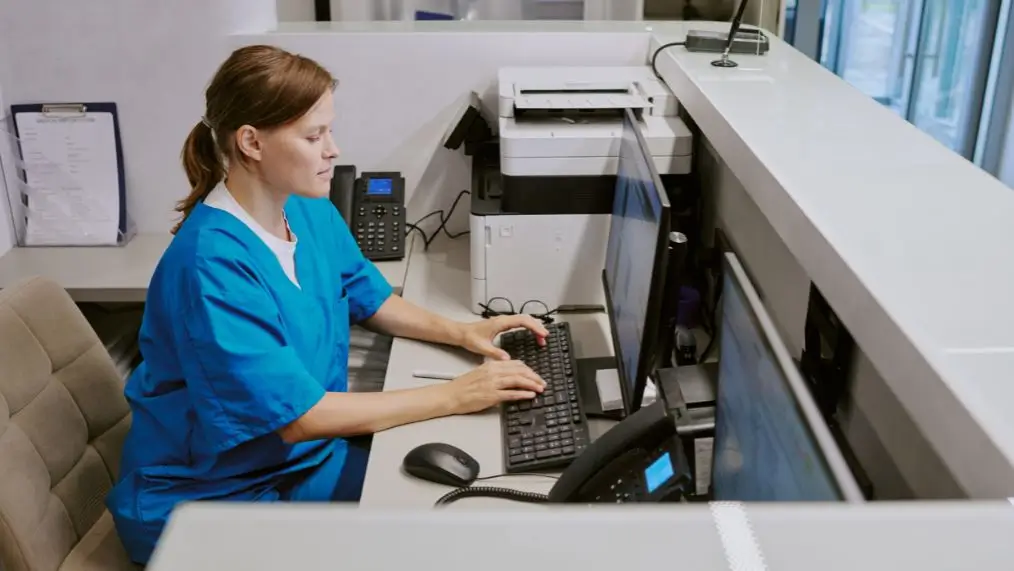 Woman in medical office typing on computer